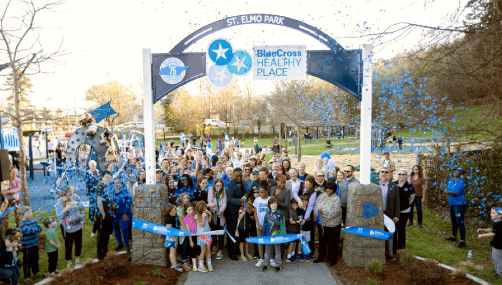 The St. Elmo BlueCross Healthy Place park archway and grand opening with members of the neighborhood and BlueCross employees cutting the ribbon.