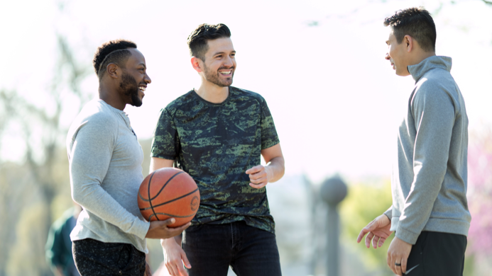 Three men talking during a basketball game