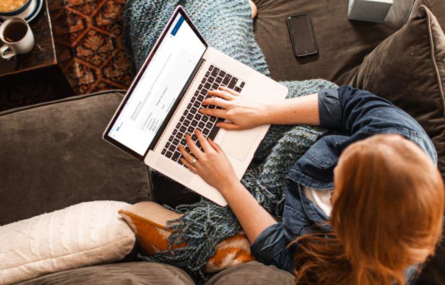 Overhead shot of a woman on her laptop looking up documents and forms