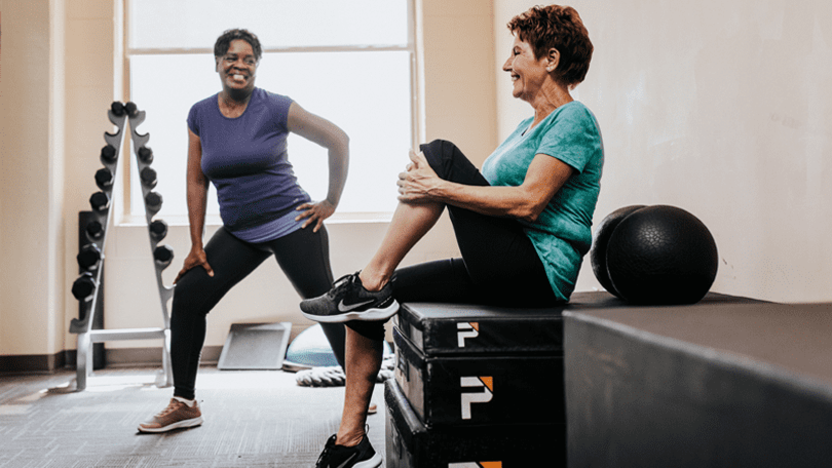 Two senior women working out together indoors