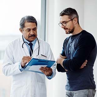 Provider and young male patient talking in office