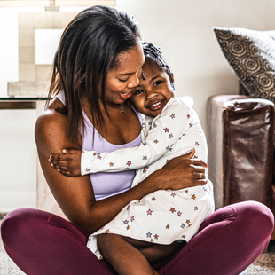 Mom and her daughter giggling and cuddling on the floor