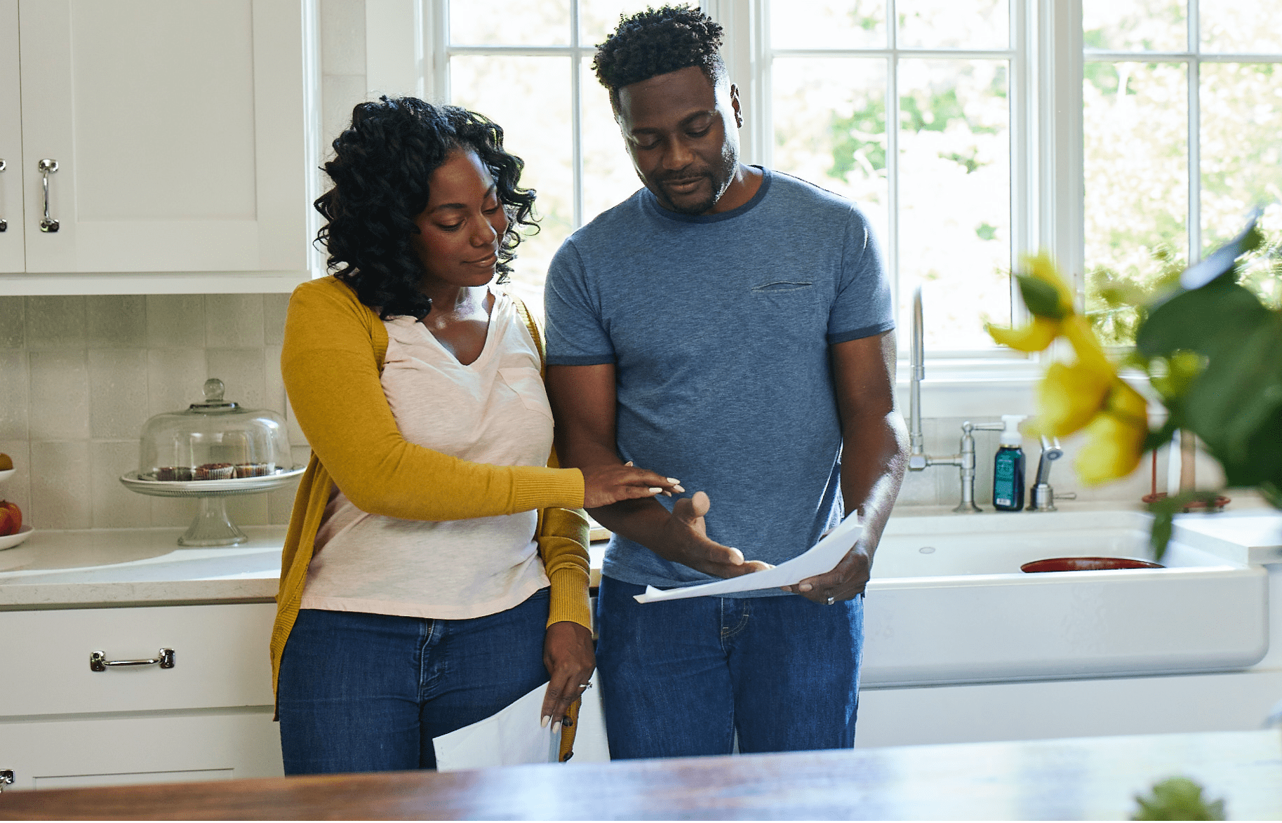 Couple in kitchen looking at paperwork Couple in kitchen looking at paperwork