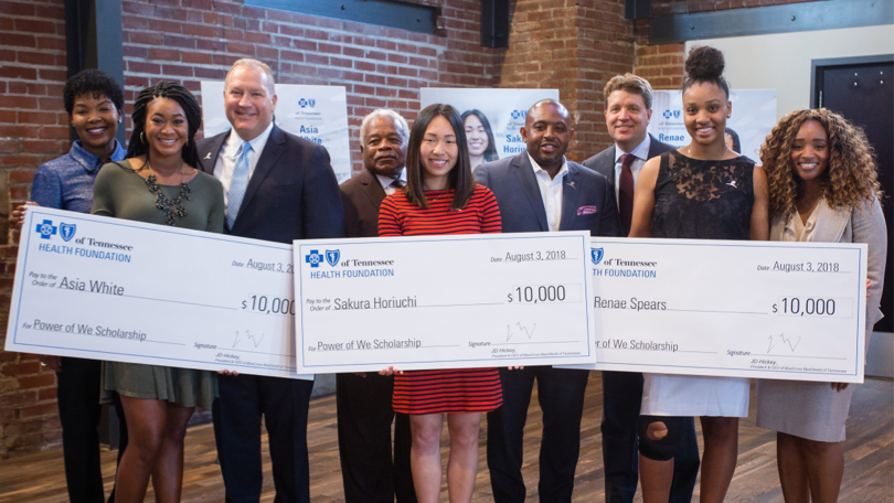 Leadership with minority students holding scholarship checks. Leadership with minority students holding scholarship checks.