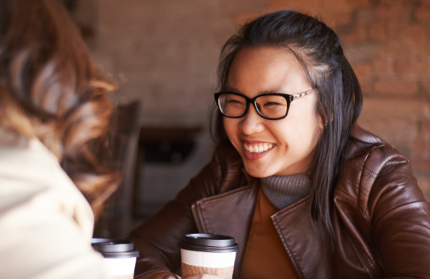 Woman smiling over coffee with a friend