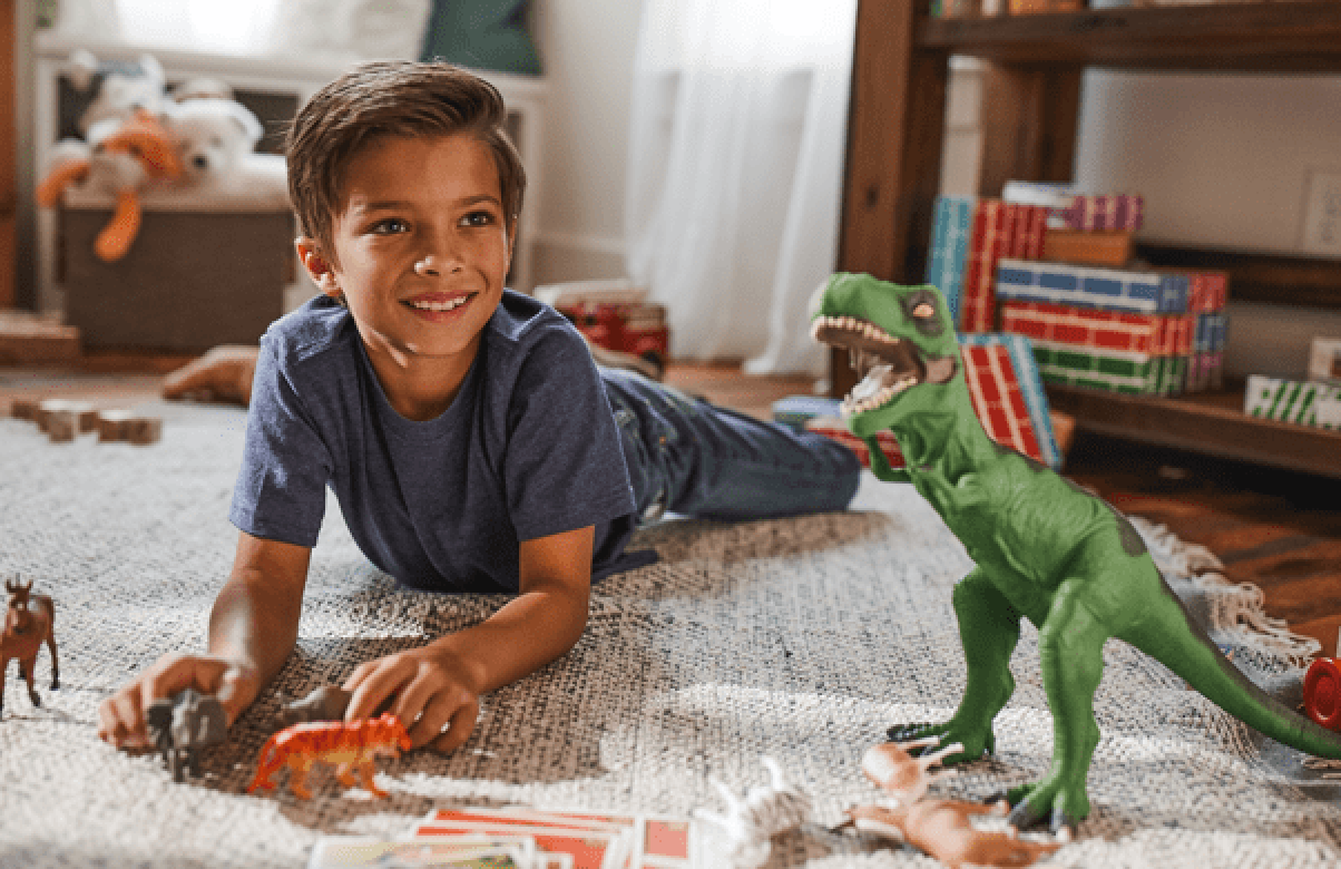 Young boy playing with toys on the floor in his bedroom