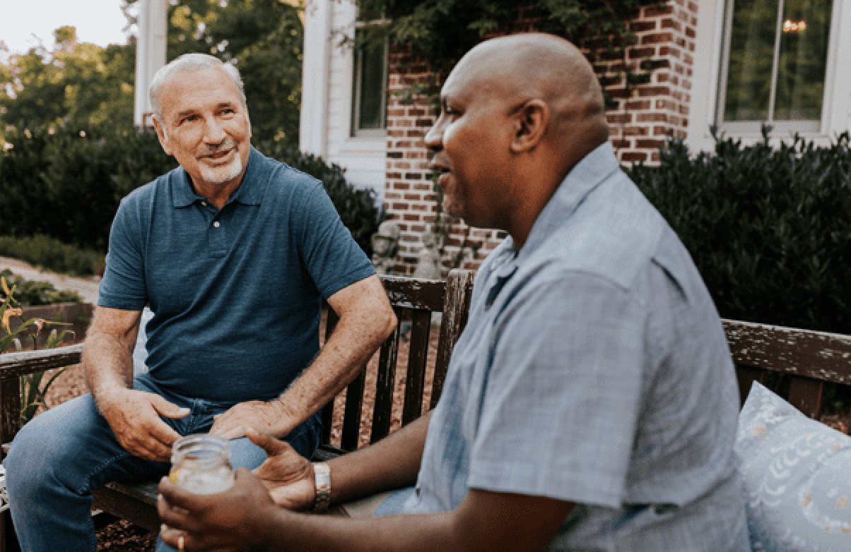 Two senior men sitting outside and talking