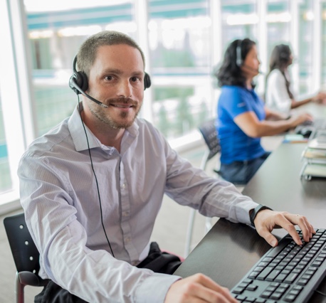 Man smiling while sitting in a call center