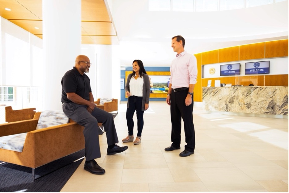 Three people in a workplace office lobby