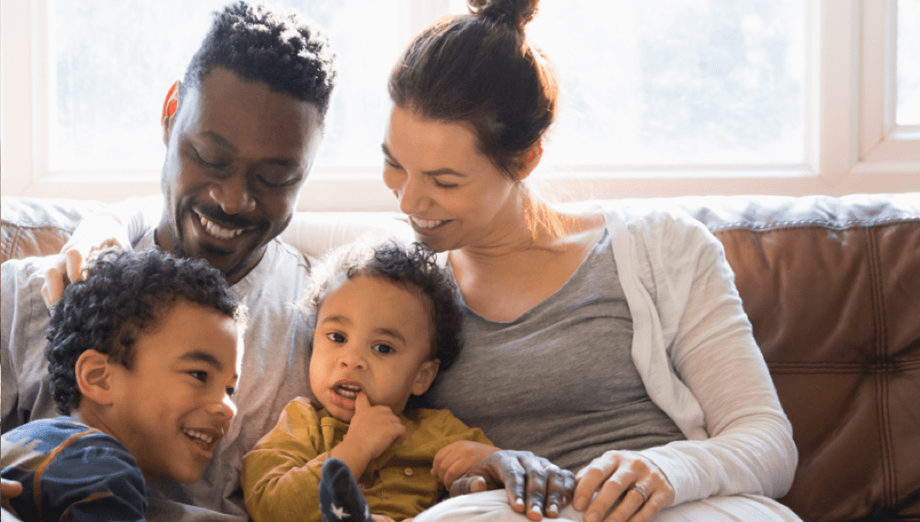 Woman and man holding children and talking