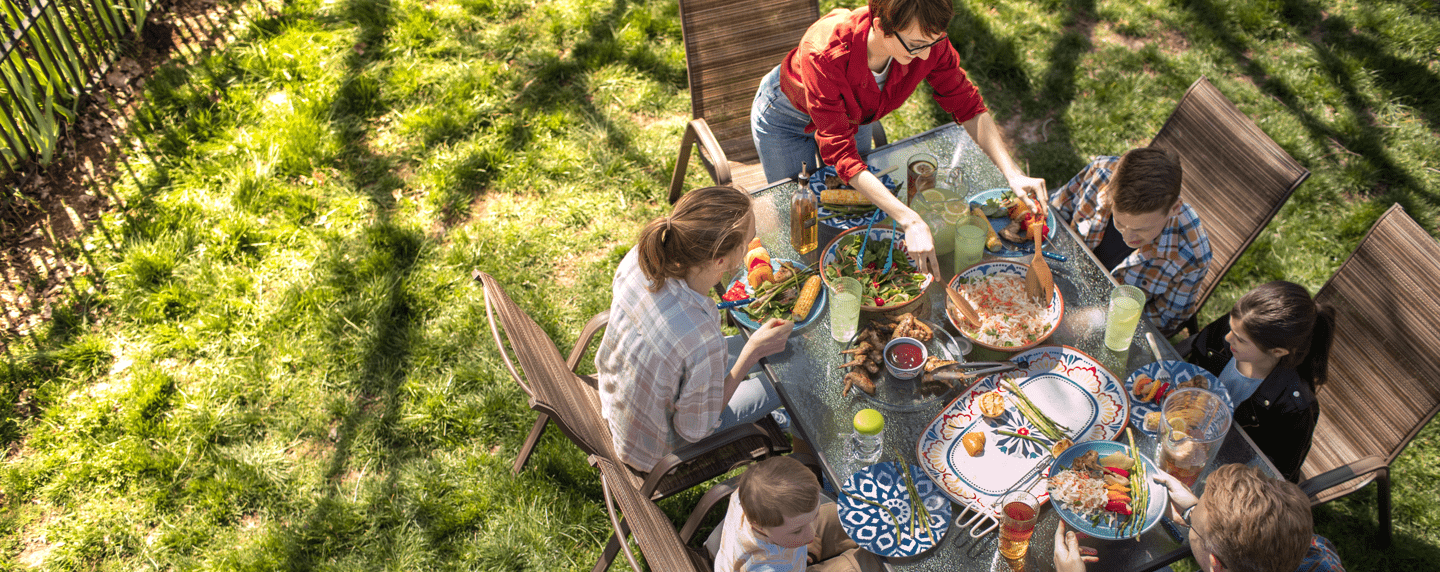 Group of people eating together outside Group of people eating together outside