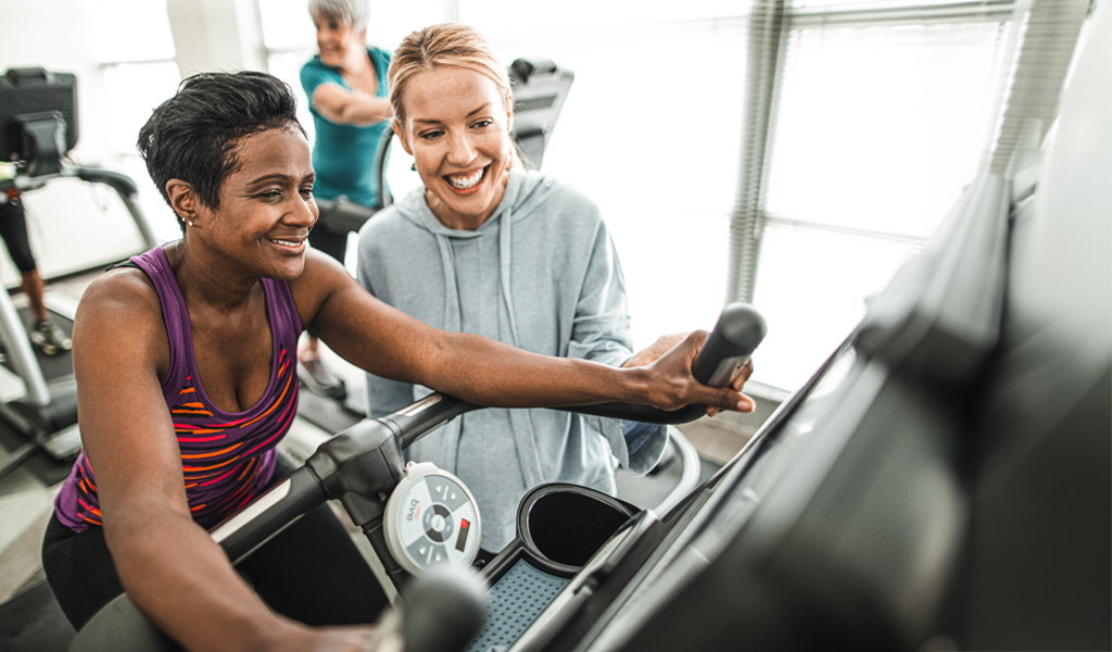 Two women in a gym operating equipment