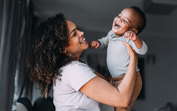 Mother and baby smiling at each other.