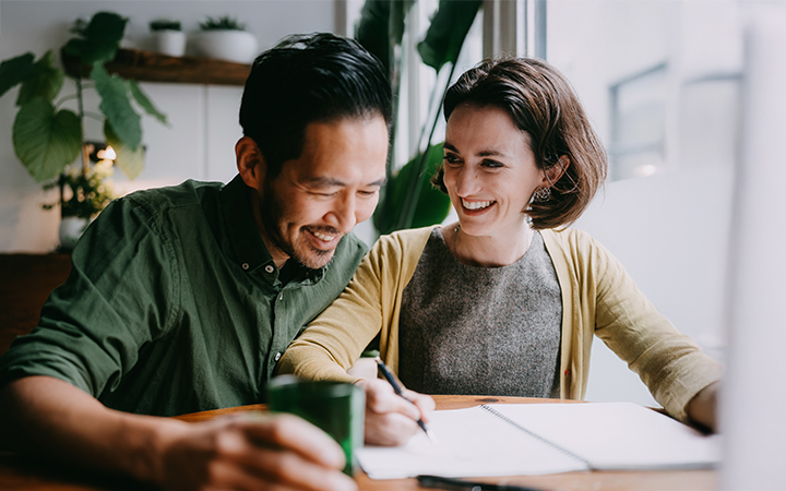A couple sitting at a table reviewing paperwork. A couple sitting at a table reviewing paperwork.