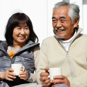 Older couple holding coffee cups and laughing