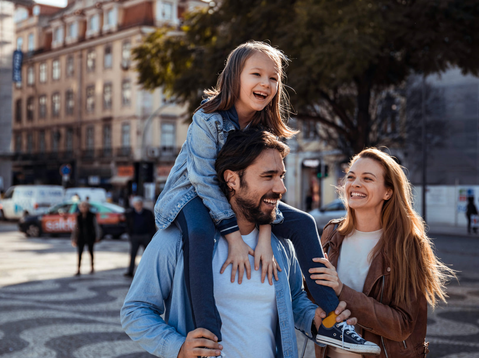 Family walking outside with child on father's shoulders