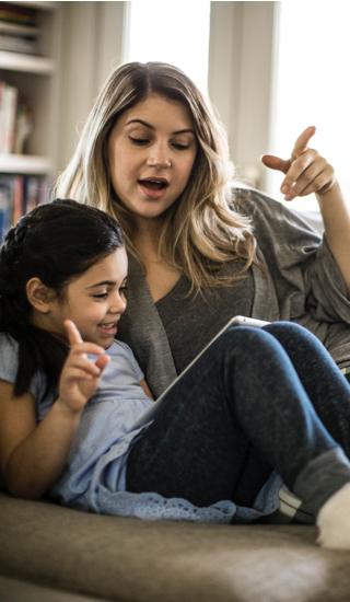 Mother and daughter using tablet on couch Mother and daughter using tablet on couch