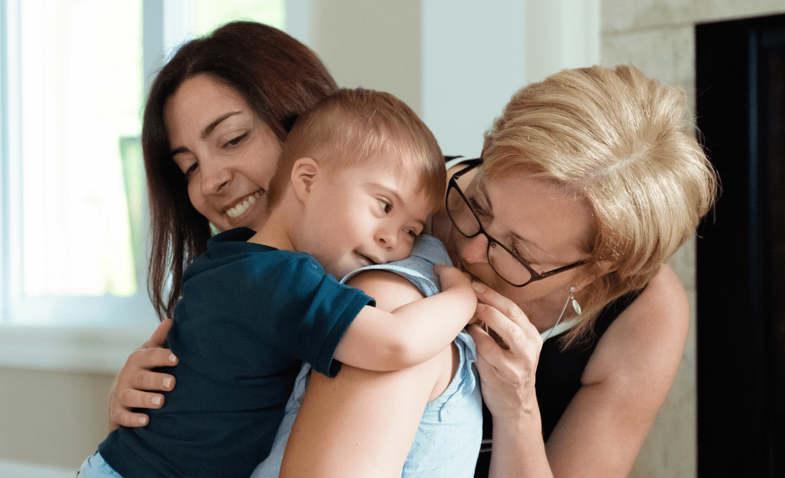 Mother and grandmother embracing special needs toddler
Mother and grandmother embracing special needs toddler