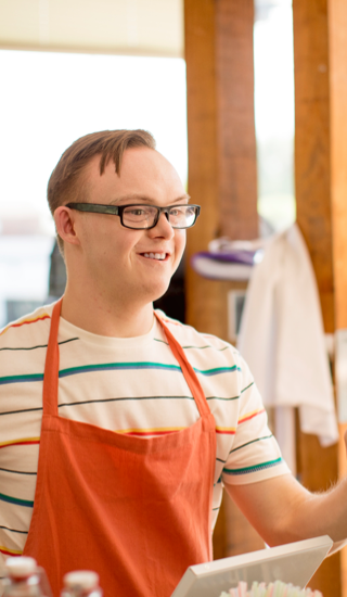 A young man at a grocery store assisting a customer A young man at a grocery store assisting a customer