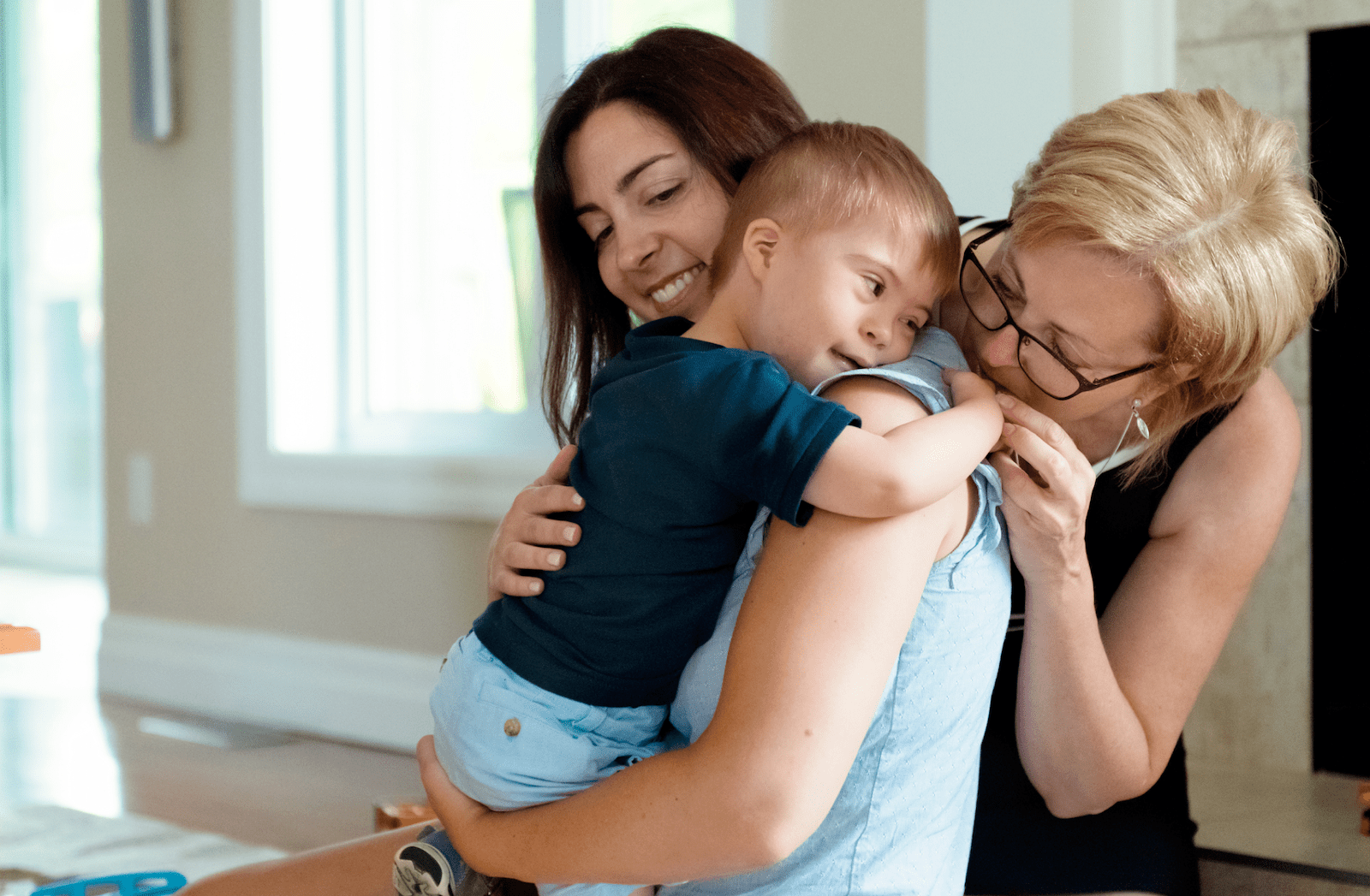 Mother and grandmother embracing special needs toddler
Mother and grandmother embracing special needs toddler