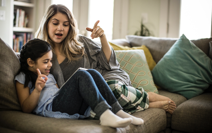 Mother and daughter using tablet on couch Mother and daughter using tablet on couch