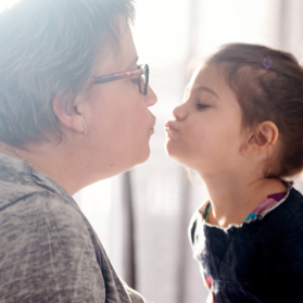 Grandmother giving a kiss to her young granddaughter Grandmother giving a kiss to her young granddaughter